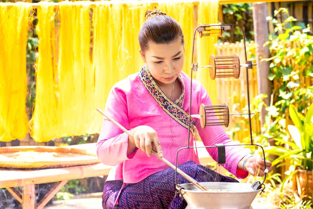 Indonesische Frau webt Stoffe